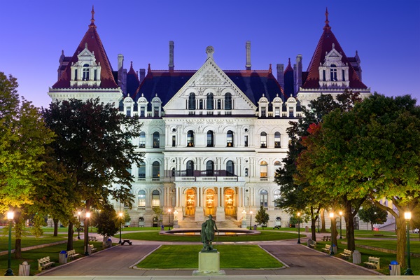 The New York State Capitol building in Albany, New York, illuminated at dusk, viewed from the park with a statue in the foreground. (622364463)